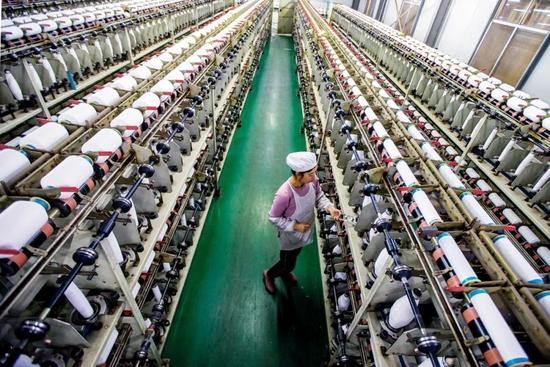 2021年10月31日,江苏南通市的一家企业内,工人赶制出口化纤产品订单.